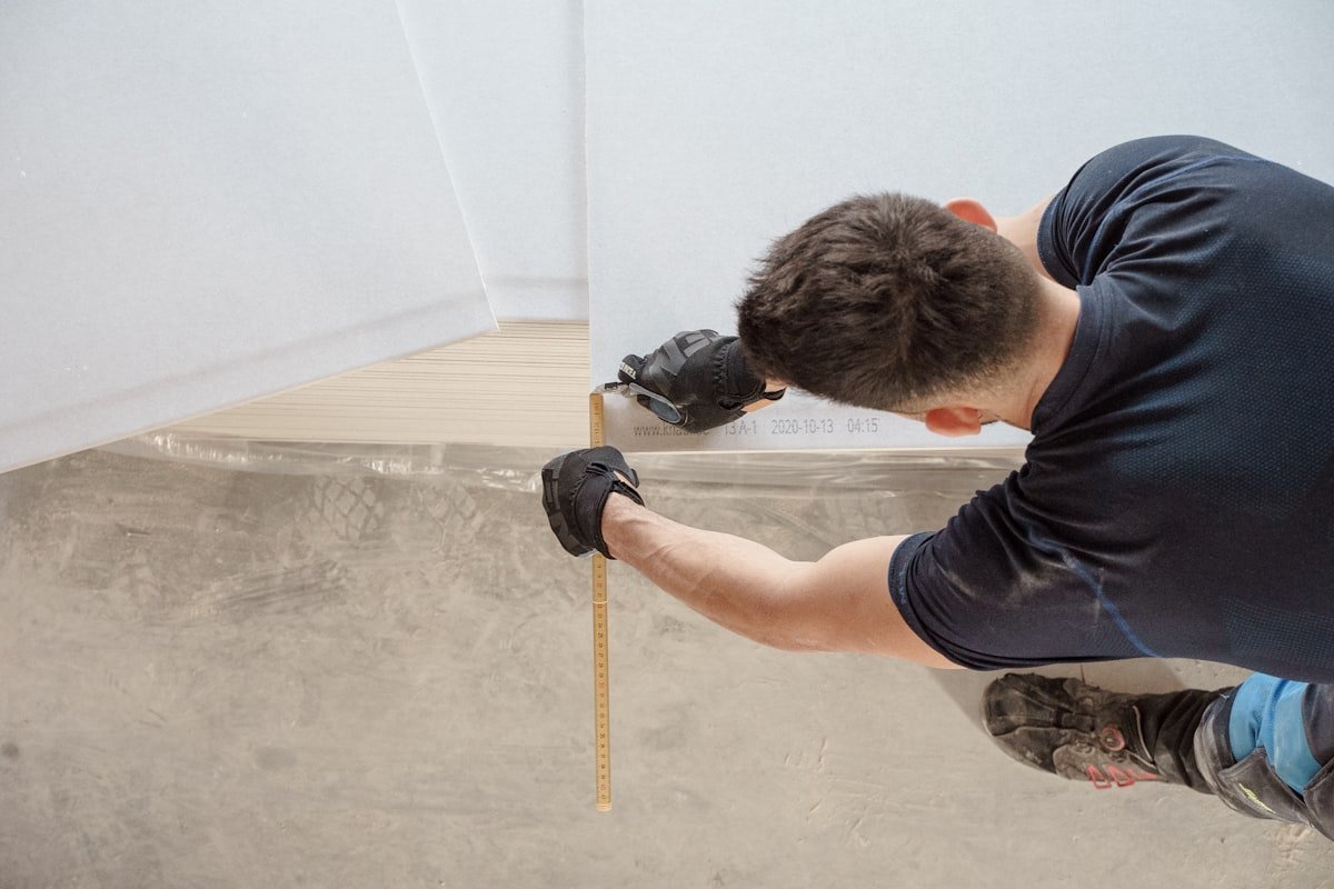 Finish carpenter measuring baseboard trim